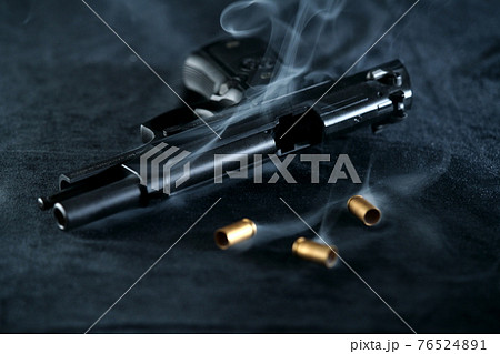 発砲後の拳銃　M92Fミリタリーモデルと薬莢 76524891