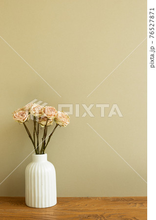 Vase of dry rose flowers on wooden table. khaki beige background 76527871