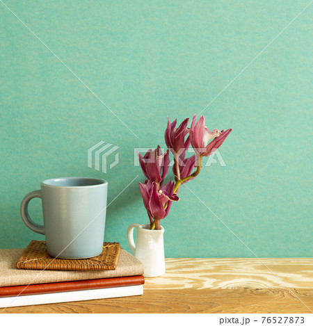 Notebook, mug cup, flower on wooden desk. green background. Work and study place 76527873