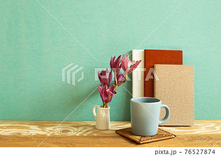 Notebook, mug cup, flower on wooden desk. green background. Work and study place 76527874