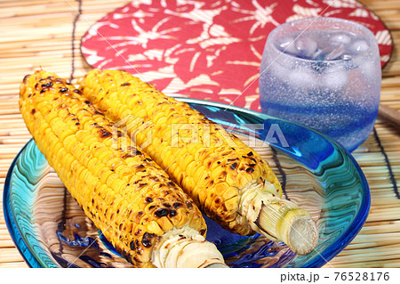 焼きとうもろこしと焼酎と団扇 76528176