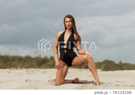 Gorgeous young female crawling on beach 76528206