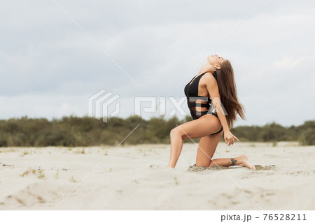 Gorgeous young female crawling on beach 76528211