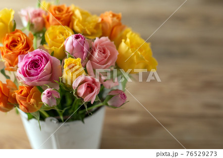 古い木のテーブルの上のバラの花 76529273