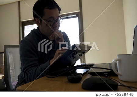 ペンタブでイラストを描く男性 76529449