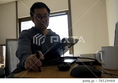 ペンタブでイラストを描く男性 76529469