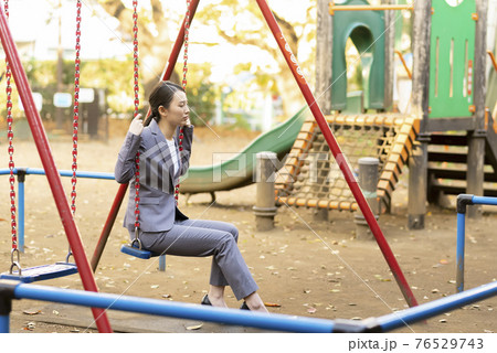 公園でたそがれる若い女性 スーツ 公園でたそがれる若い女性 スーツ 76529743