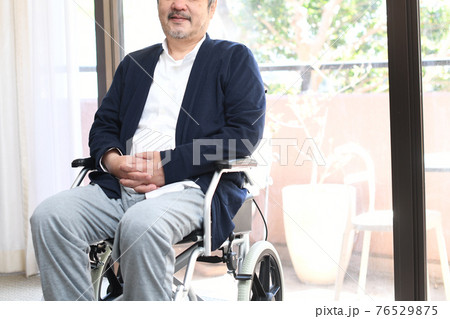 車椅子に乗る笑顔のシニア男性 76529875