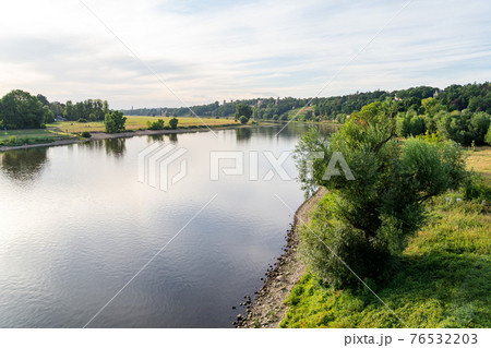 Horizon of green hills with villas, calm river and lawn with a path Horizon of green hills with villas, calm river and lawn with a path 76532203