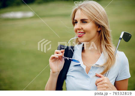 Beautiful girl playing golf on a golf course Beautiful girl playing golf on a golf course 76532819