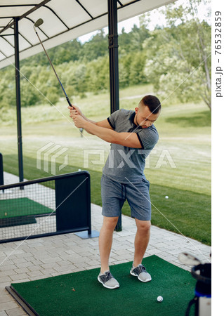 Handsome man playing golf on a golf course 76532859