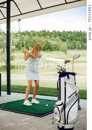 Beautiful girl playing golf on a golf course Beautiful girl playing golf on a golf course 76532861