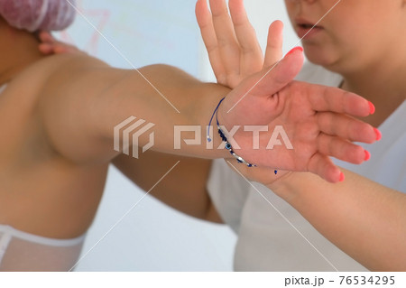 Woman doctor of osteopathy masseur is doing massage to woman in standing pose. 76534295