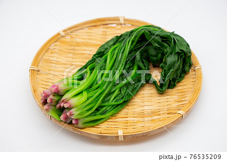 ザルに乗せた茹でたほうれん草　根が赤い栄養豊かな野菜 76535209