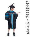 Cute Asian child in graduation gown show something copy space.Commercial advertisement. Promotion concept. Promoting product for kids. 76535447