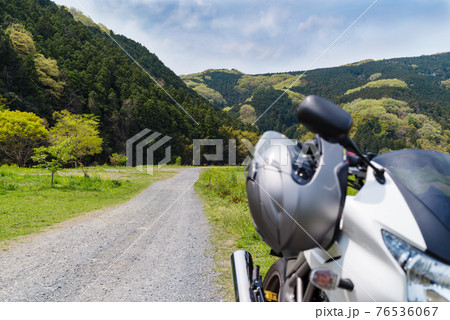 春のバイクツーリング 木々が萌える里山の一本道 ヘルメットとカウル　d-1 前ボケ 76536067