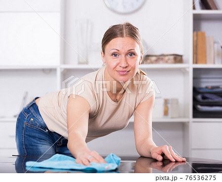 Cheerful woman wiping table Cheerful woman wiping table 76536275