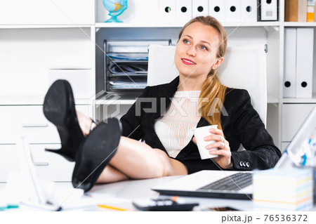 Girl drinking water and lying legs on table 76536372