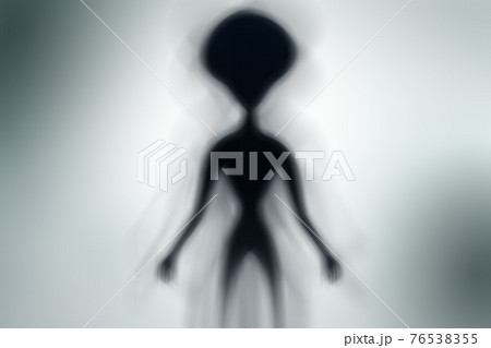 Silhouette of spooky alien and bright light on behind him Silhouette of spooky alien and bright light on behind him 76538355