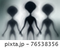 Silhouettes of spooky aliens and bright light on behind them 76538356