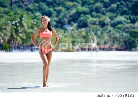 Sexy girl in red swimsuit posing at the tropical beach Sexy girl in red swimsuit posing at the tropical beach 76539133