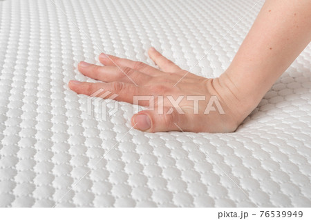 Woman is choosing new mattress for good sleeping 76539949