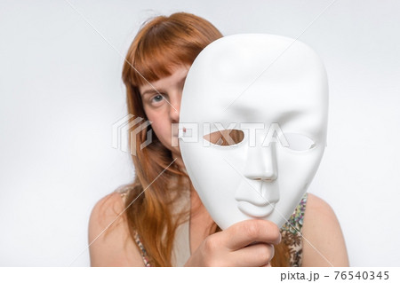 Mysterious woman cover her face behind anonymous mask 76540345