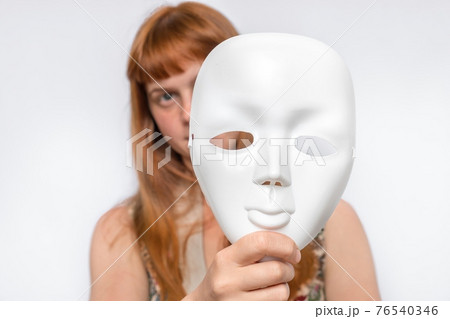 Mysterious woman cover her face behind anonymous mask 76540346