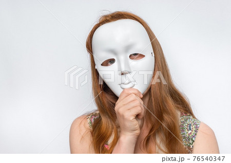 Mysterious woman cover her face behind anonymous mask 76540347
