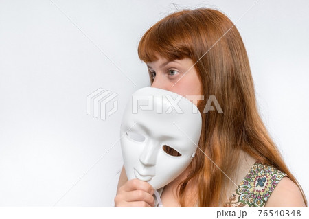 Mysterious woman cover her face behind anonymous mask 76540348