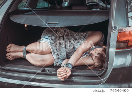 Woman with tied hands inside car trunk - kidnapping 76540400