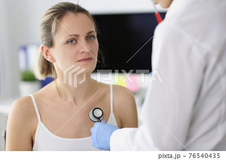 Patient listens to patient lungs through stethoscope Patient listens to patient lungs through stethoscope 76540435