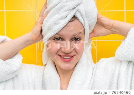 Smiling woman in bathrobe with towel on her head 76540460