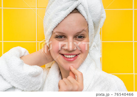 Smiling woman in bathrobe with towel on her head 76540466