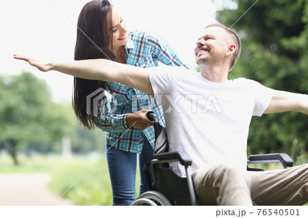 Happy man in wheelchair for walk with woman Happy man in wheelchair for walk with woman 76540501