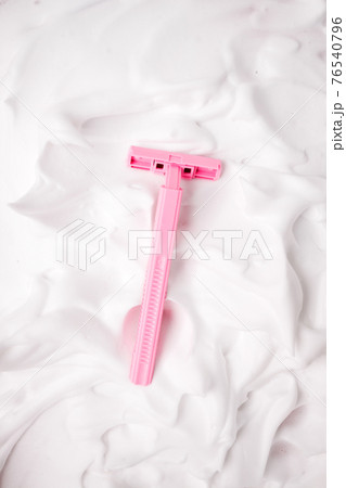 White cosmetic foam texture background. Cosmetic mousse, cleanser, shaving foam, shampoo and pink girly razor. Foamy skin care product, skincare, female hygiene concept, copy space 76540796