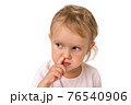 Baby girl is picking her nose with finger inside 76540906