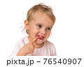 Little baby with finger inside mouth 76540907