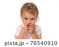 Baby girl is picking her nose with finger inside 76540910