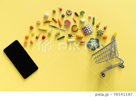 Online shopping concept - different foods and phone on yellow background 76541197