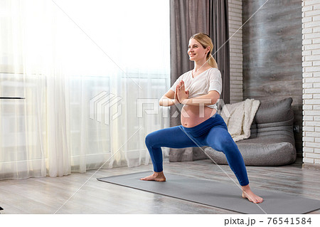 Happy pregnant caucasian woman training yoga at home Happy pregnant caucasian woman training yoga at home 76541584