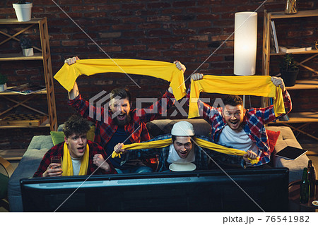Group of friends watching TV, sport match together. Emotional fans cheering for favourite team, watching on exciting game. Concept of friendship, leisure activity, emotions 76541982