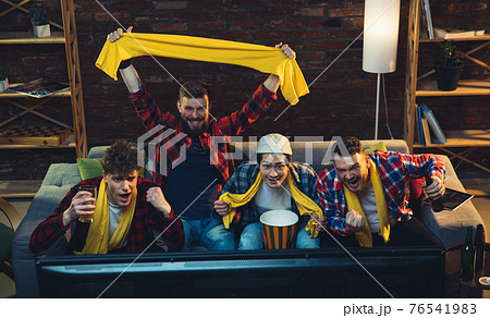 Group of friends watching TV, sport match together. Emotional fans cheering for favourite team, watching on exciting game. Concept of friendship, leisure activity, emotions 76541983