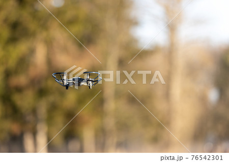 Small drone with little camera flying in the park 76542301