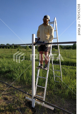 The master cuts a metal fence with an angle grinder, construction work. The master cuts a metal fence with an angle grinder, construction work. 76543208