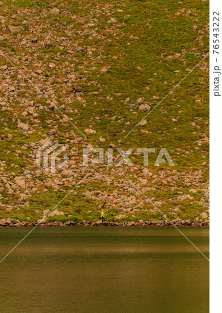Two boys are standing by the water, two brothers are looking at the lake, the reflection in the water, the alpine lake Brebeneskul. 76543222