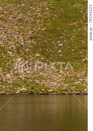 Two boys are standing by the water, two brothers are looking at the lake, the reflection in the water, the alpine lake Brebeneskul. 76543223
