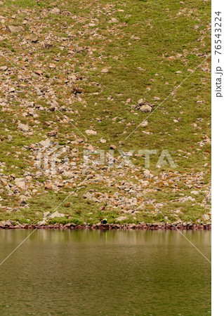 Beautiful and picturesque Carpathian lake Brebeneskul, a guy on the edge of the lake, the edge of the mighty mountains, a lake in the valley. 76543224