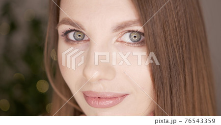 Beauty woman face with green eyes looking at camera. Skin care treatment or cosmetic ads concept. Beautiful female model with perfect fresh and clean skin. Nude make-up. In studio. 76543359