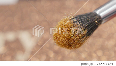 Brush gains glitter to be used in make-up. Macro view of working process, tools in beauty industry. Fashion glamour shiny glitter concept. Brush gains glitter to be used in make-up. Macro view of working process, tools in beauty industry. Fashion glamour shiny glitter concept. 76543374
